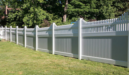 White vinyl fence in a residential yard, showcasing a classic design that enhances property security and curb appeal, relevant to Joe's Fencing & Gates Corona services.