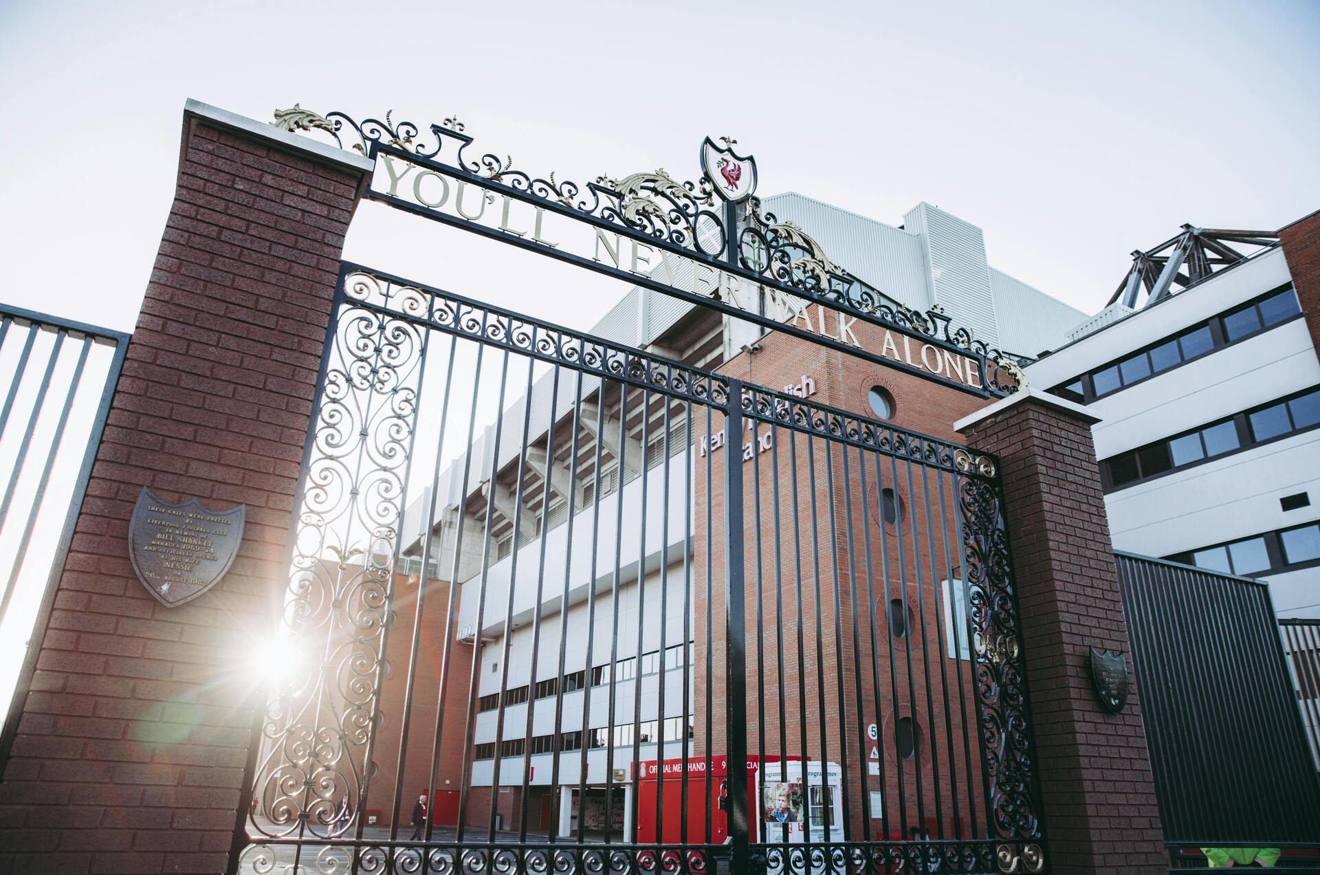 Entrance gate with ornate design and the phrase "YOU'LL NEVER WALK ALONE," leading to a sports stadium, symbolizing community and support in Corona, CA.