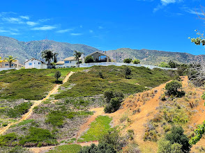 Scenic hillside view of residential properties in Corona, California, showcasing natural landscapes and modern living, relevant to fencing and gate solutions.