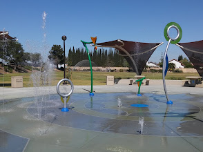 Colorful water play area with artistic fountains and shade structures, ideal for enhancing community spaces in Corona, California.